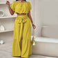Set di due pezzi composto da top con spalle scoperte e maniche a sbuffo e pantaloni a gamba larga
